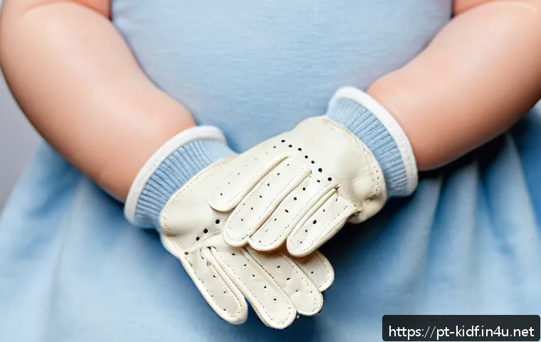 유아용 가죽 장갑 - A close-up image of a baby’s hands wearing soft natural leather gloves, highlighting the smooth text...